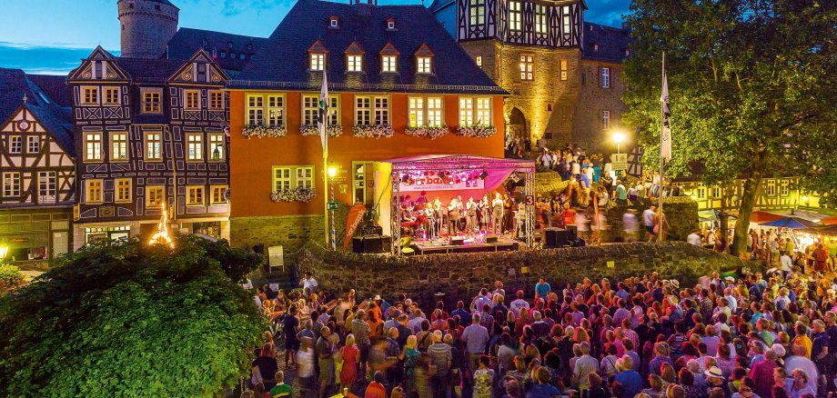 Feiernde Menschen in der Dämmerung vor der Kulisse des Rathauses