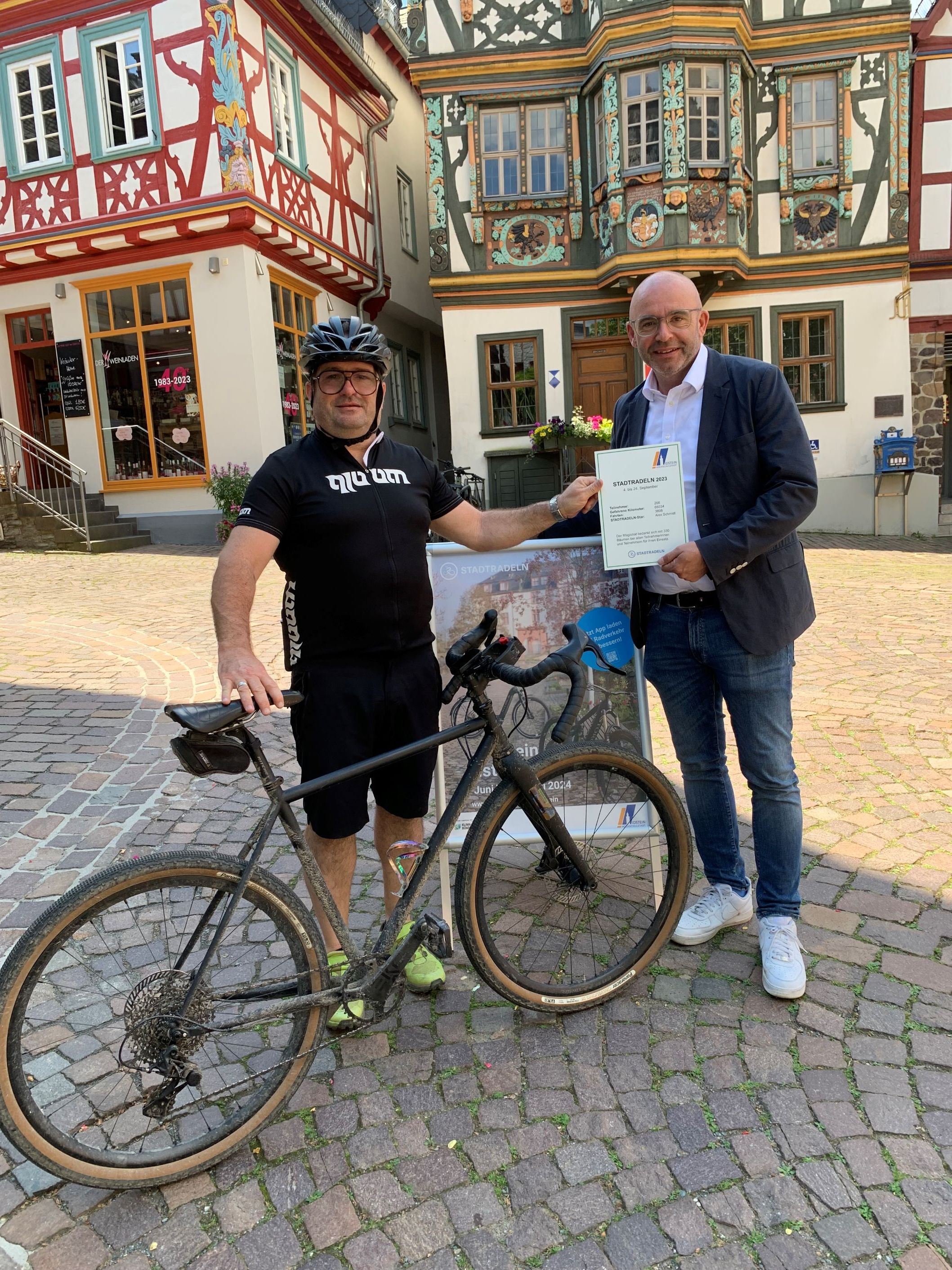 Stadtradel-Star Alex Schmidt und Bürgermeister Christian Herfurth mit einem Fahrrad vor dem Killingerhaus