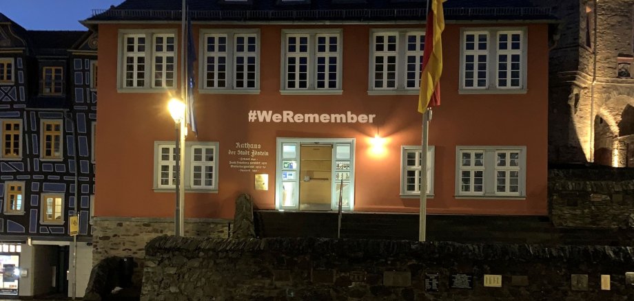 leuchtender Schriftzug WeRemember über der Rathaustür