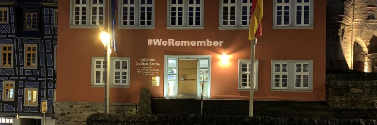 leuchtender Schriftzug WeRemember über der Rathaustür