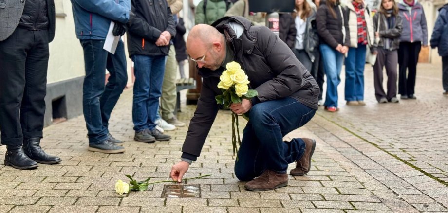 Bürgermeister Christian Herfurth legt Rosen an Stolpersteinen zu Erinnerung nieder