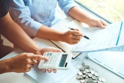 Hände mit Taschenrechnern