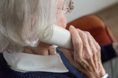 Trickbetrug Ältere Frau mit Telefonhörer in der Hand