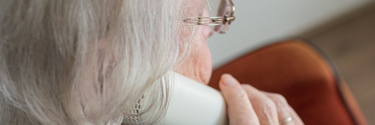 Ältere Frau mit Telefonhörer in der Hand