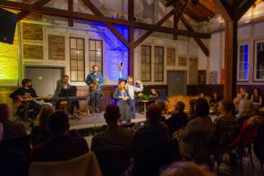 Kleinkunst  im Kulturbahnhof 3 Künstler mit Musikinstrumenten im Hintergrund und 2 Künstler im Vordergrund