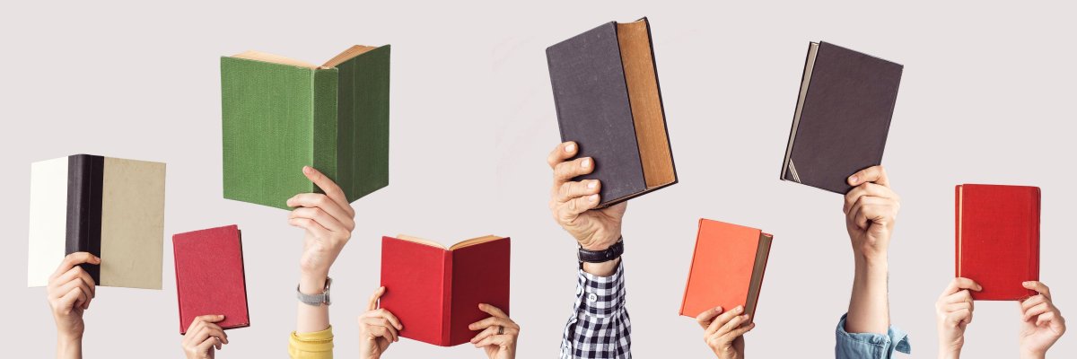Mehrere Hände nebeneinander halten Bücher in die Höhe